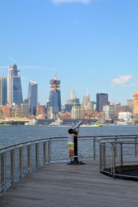 Rear view of boy looking cityscape through coin-operated binoculars