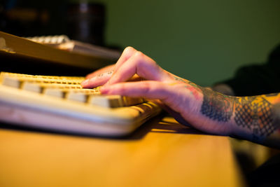 Cropped hand of woman using computer at home