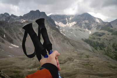 Close-up of female hands with trekking poles for nordic walking against the background of the alpine