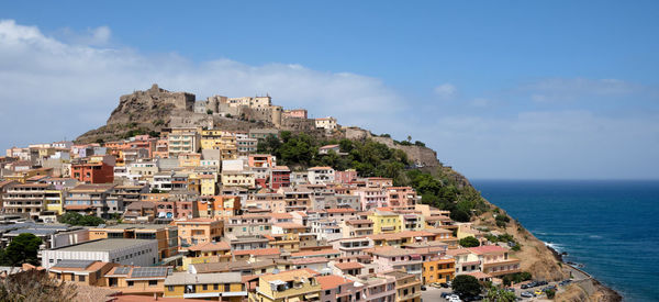 Houses by sea against sky in town