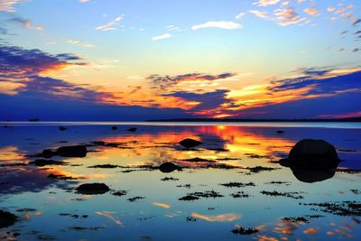 Scenic view of sea against cloudy sky during sunset