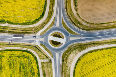 High angle view of yellow road amidst field