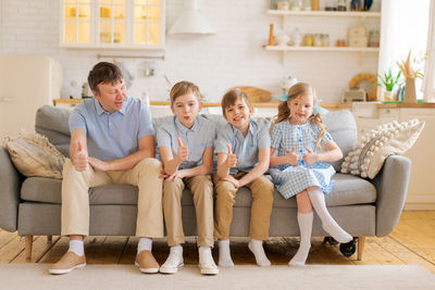 Happy overjoyed father family with small children. sports fans watching tv game