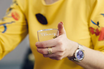 Close-up of hand holding yellow text