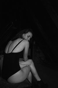 Side view of young woman sitting at home