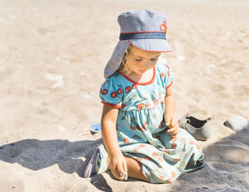 Girl wearing hat on sand at beach