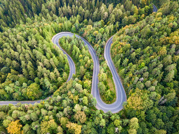 Winding road from high mountain pass, in summer time. aerial view by drone. romania