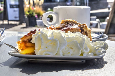 Apple pie with cream on a sunny day