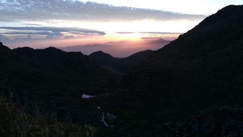 Scenic view of silhouette mountains against sky at sunset