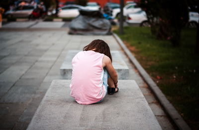 Little girl sitting alone on the bench