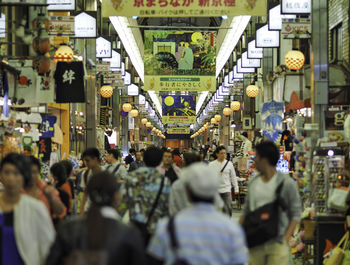 People amidst market stalls in city