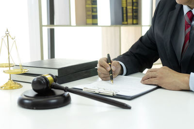 Cropped image of hand with open book on table