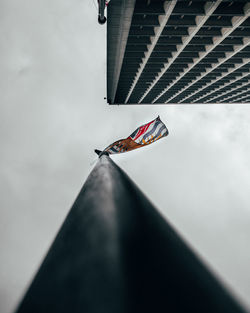 Low angle view of flag on roof against sky