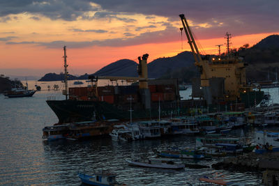 Fishing boats in sea at sunset