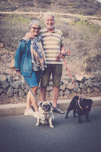 Senior couple with dogs on road