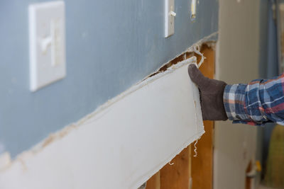 Midsection of man standing by wall