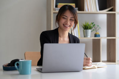 Young woman using laptop on table