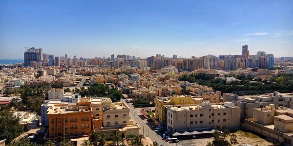 Aerial view of buildings in city against sky