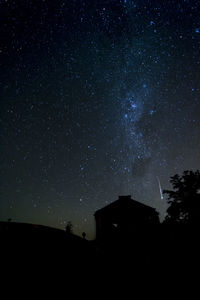 Low angle view of silhouette building against sky at night