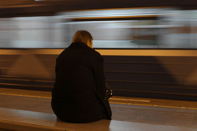 Rear view of woman on train at railroad station platform