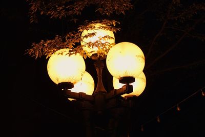 Low angle view of illuminated light bulb against sky