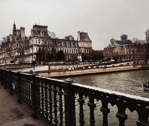 Bridge over river against buildings in city