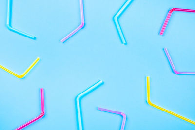 Blue background of colored plastic straws with place for text.
