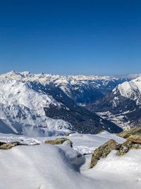 Scenic view of snowcapped mountains against clear blue sky