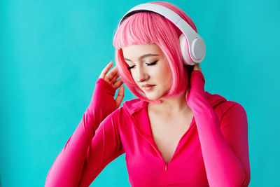 Portrait of woman wearing mask against blue background