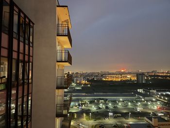 Illuminated buildings in city against sky at dusk