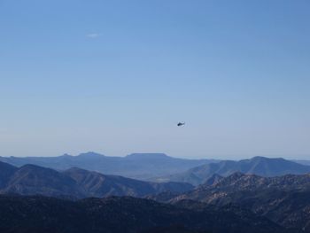 Bird flying over mountains against clear sky