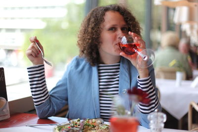 Portrait of woman drinking wine at restaurant