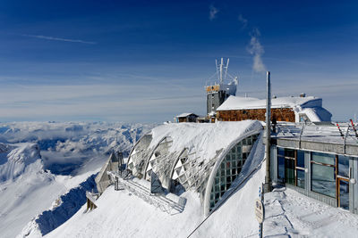 Panoramic view of snow covered mountain against blue sky