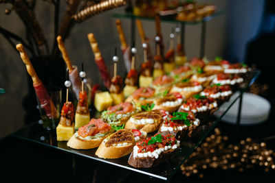 Luxury glass table with canapes on skewers. canapes with a variety of cheeses, salmon, salsa.