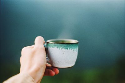 Close-up of hand holding coffee cup