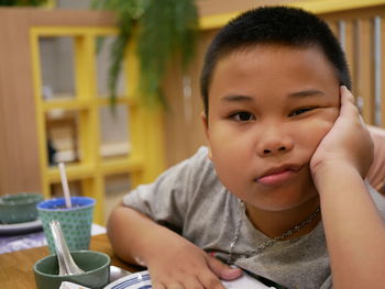 Portrait of cute boy sitting on table