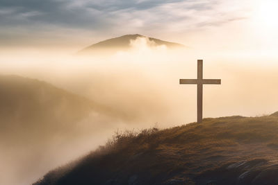 Cross in the fog on the morning mountain