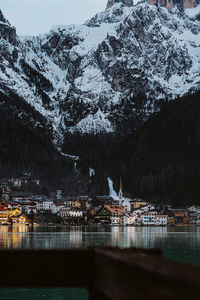 Built structure by lake against mountain during winter