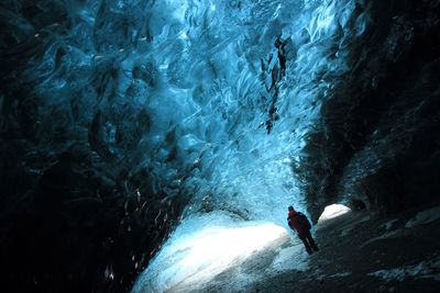 Rear view full length of man standing in ice cave