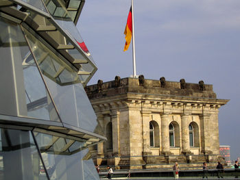 Low angle view of flag against built structure