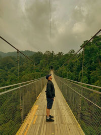 Rear view of man walking on road against sky