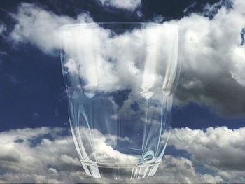 Digital composite image of glass against cloudy sky