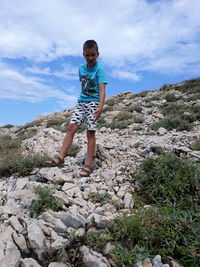 Full length of boy standing on rocks