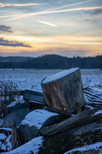 Abandoned boat on shore against sky during sunset