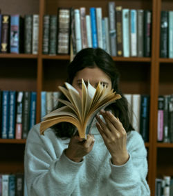 Midsection of man holding book at home