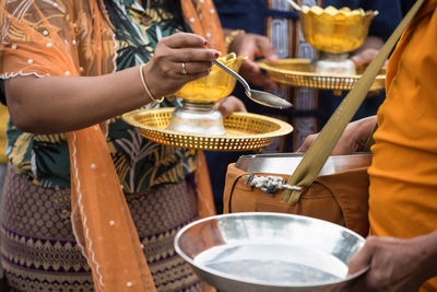 Mon people offer  rice and food to buddhist monk alms bowl in sangkhlaburi, kanchanaburi, thailand.