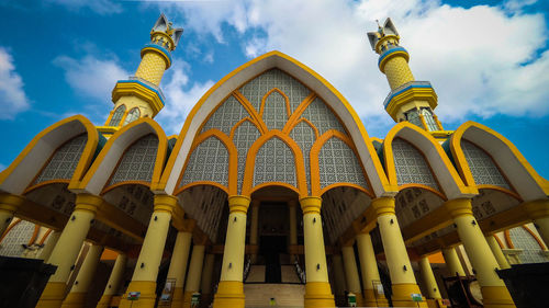 Low angle view of yellow building against sky