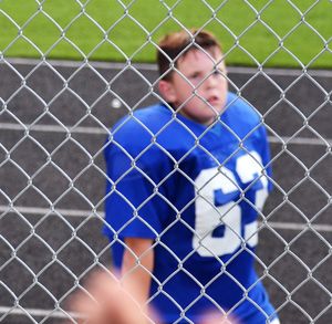 High angle view of american football player seen through chainklink fence