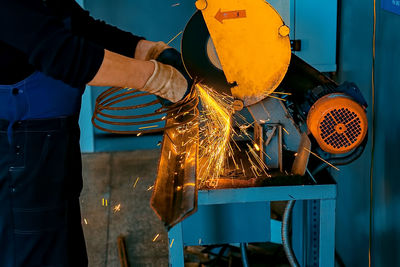 Midsection of man working on metal