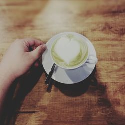 High angle view of hand holding coffee cup